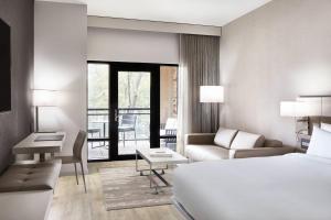 夏洛特AC Hotel by Marriott Charlotte SouthPark的酒店客房配有一张床、一张沙发和一张书桌。