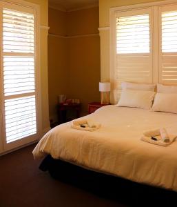 悉尼摩特雷克悉尼皇宫酒店的卧室设有一张带窗户的白色大床