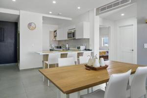 奥拉涅斯塔德Milateo Suite的厨房以及带木桌和椅子的用餐室。