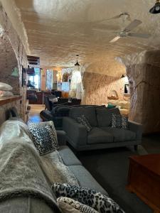 库伯佩迪盯奇迪杜古度假屋的带沙发和石墙的客厅