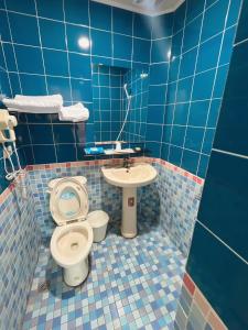 北港镇日日 Meworld的蓝色瓷砖浴室设有卫生间和水槽