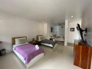 长滩岛Everrich Boutique Resort Boracay的一间卧室配有两张床和一台平面电视