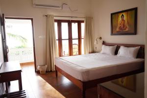 可瓦兰Buddha Beach Hotel的一间卧室设有一张大床和一个窗户。