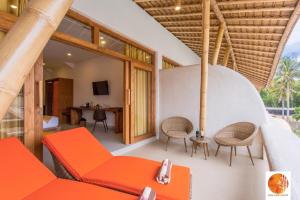 吉利特拉旺安Pearl Sunset Resort的客厅配有橙色沙发和椅子