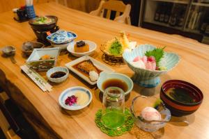 本宫Guest House Takiyoshi的一张木桌,上面放着食物盘