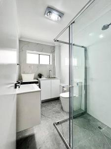 IngleburnBrand new 2 Bedrooms Apartment in Ingleburn的带淋浴、盥洗盆和卫生间的浴室
