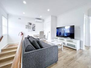 IngleburnBrand new 2 Bedrooms Apartment in Ingleburn的带沙发和电视的客厅