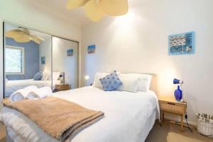 BrightonEagles Nest Two Bed Home Nudgee Beach的卧室配有一张白色大床和镜子
