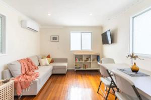 BrightonEagles Nest Two Bed Home Nudgee Beach的客厅配有沙发和桌子