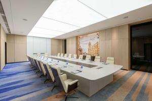 上海上海虹桥睿景酒店的大型会议室,配有长桌子和椅子