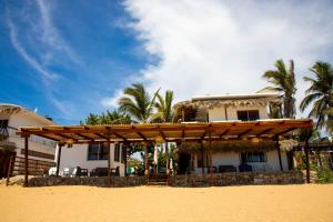 兹波利特Hotel Playa Zipolite的海滩上带木制凉棚的房子