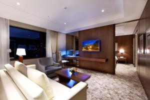 蔚山Hotel Hyundai by Lahan Ulsan的客厅配有白色沙发和电视