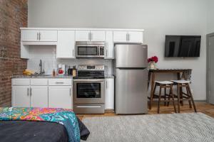 落基山The Davis Lofts at Main Street - Unit 3D的厨房配有白色橱柜和不锈钢用具