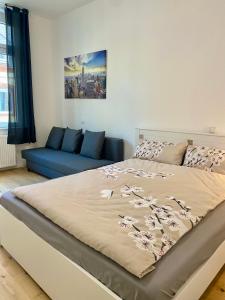 科布伦茨PnT home-stilvolles Apartment的一间卧室配有一张床和一张蓝色的沙发