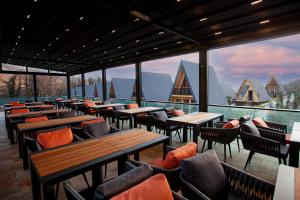 拉戈代希Reserve Resort Lagodekhi的餐厅设有木桌、椅子和窗户。