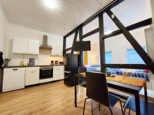 布尔沙伊德1 Room Apartment in Burscheid的厨房以及带桌椅的用餐室。