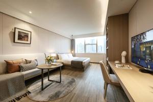 深圳深圳东门壹棠服务公寓的客厅配有床、沙发和桌子