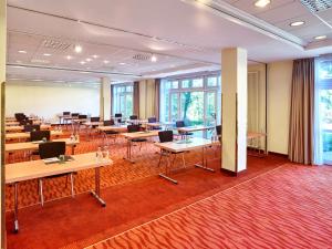 代德斯海姆MAXX by Steigenberger Deidesheim的一间会议室,配有桌椅和窗户