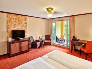代德斯海姆MAXX by Steigenberger Deidesheim的酒店客房,配有床和电视