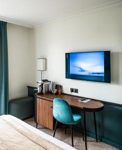 布洛涅-比扬古巴黎布洛涅酒店的酒店的客房,设有书桌和墙上的电视