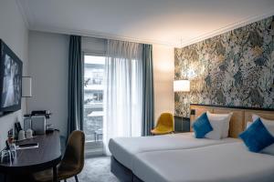 布洛涅-比扬古巴黎布洛涅酒店的酒店客房设有两张床、一张书桌和一个窗户。
