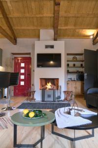 Makris GialosYasemia Wood & Stone Villa的客厅配有桌子和壁炉