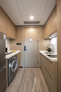 深圳深圳东门壹棠服务公寓的厨房配有洗衣机和烘干机,设有门