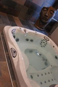 Saint-Jeure-dʼAyL'espaco的浴室里设有浴缸,浴缸里还装饰着男人的雕像