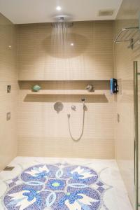 新加坡3号航站楼大使过境休息室酒店的浴室设有地板上的地毯和淋浴。