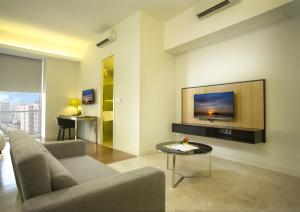 吉隆坡吉隆坡服务式套房签名酒店的客厅配有沙发和墙上的电视