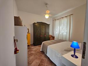 圣维托罗卡波La Casa Di Aceste的一间卧室配有一张床和一张桌子上的蓝色灯