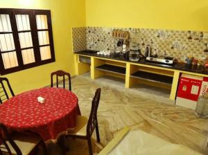 蓬蒂切里Smith 5BHK Villa的一间带红色桌子的用餐室和一间厨房