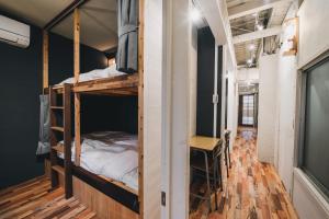 高松コトリ コワーキング&ホステル高松的客房设有两张双层床和一张书桌。