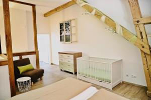 诺伊基希Ferienhof König的阁楼卧室配有婴儿床和椅子