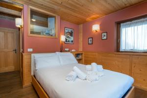 瓦尔布鲁纳Valbruna Inn Bed & Breakfast的一间卧室配有一张床,上面有两条毛巾