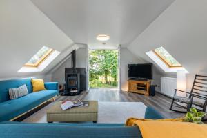 LochwinnochStylish 2 bedroom Cottage near Glasgow Airport的客厅配有蓝色的沙发和电视