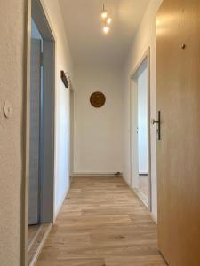 Gästewohnung KL. WZL 31_7的空的走廊设有白色的墙壁和木地板