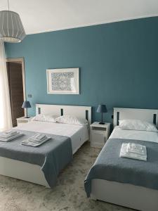 巴里Interno2 Bari Centrale的卧室设有两张床铺和蓝色的墙壁