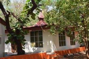 蒂鲁瓦纳马莱arulmigu sivasakthi siddhar peedam garden guest house的白色的房屋,有红色和白色的屋顶