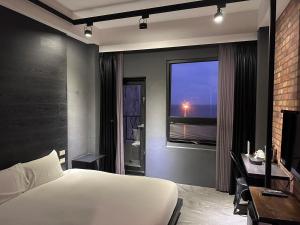 盐寮窗外的海 - 海洋公園旁的卧室配有白色的床和窗户。