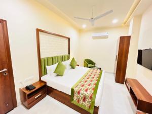 阿姆利则Hotel The Orchid Tree Amritsar - walking from Golden Temple的一间卧室配有一张带绿床罩的床