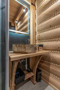 乌斯特龙Apartamenty w Lipowskiej Chacie - jacuzzi i sauna的木制柜台上带石水槽的浴室