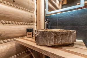 乌斯特龙Apartamenty w Lipowskiej Chacie - jacuzzi i sauna的浴室设有木制柜台上的大岩槽