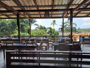 SantʼAnaCasa Cantagalo - Guest House & Bar Restaurant的一间设有桌椅的餐厅,种植了棕榈树