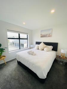 基督城Home sweet home Christchurch Centre的卧室配有一张大白色床和窗户