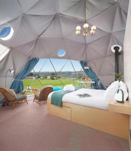 LochwinnochThe Dome at Mid Auchengowan的一间卧室配有带一张床和椅子的帐篷