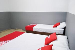 圣保罗OYO Hotel Brás的配有红色和白色枕头的客房内的两张床