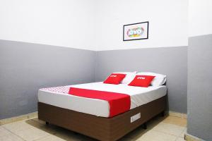 圣保罗OYO Hotel Brás的一间卧室配有红色和白色枕头的床
