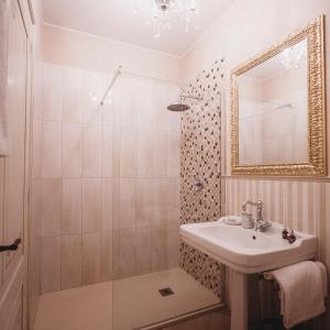 摩德纳萨洛托阿尔阿提酒店的浴室配有盥洗盆和带镜子的淋浴