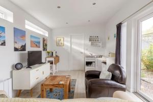 TarvesCosy and modern 1 bedroom garden house - very dog friendly!的客厅配有电视、沙发和桌子